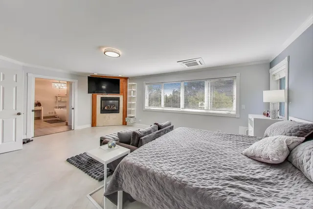 a spacious bedroom with a bed and a flat screen television