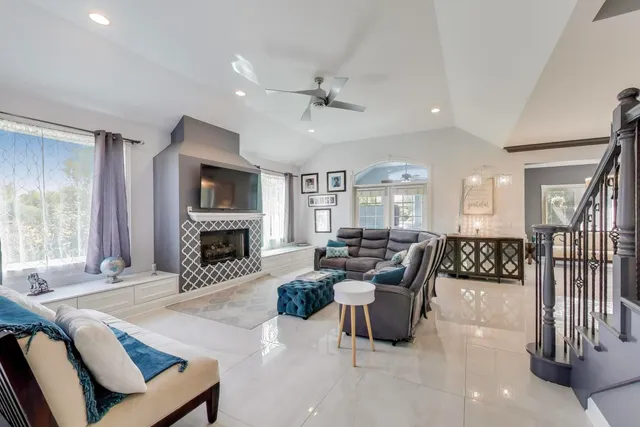 a living room with furniture fireplace and a large window