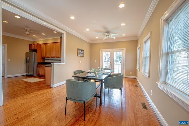 a living room with stainless steel appliances granite countertop furniture wooden floor and a kitchen view