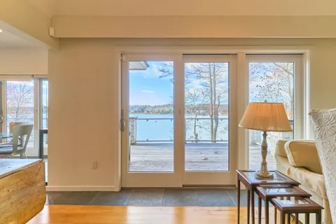 a living room with fireplace furniture and a large window