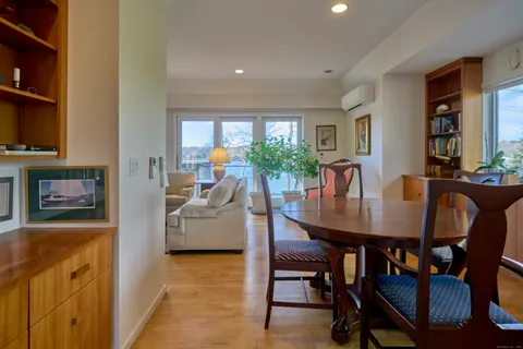 a dining hall with stainless steel appliances granite countertop a stove and a view of living room