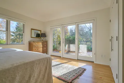 a living room with furniture a large window and wooden floor