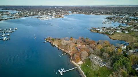 an aerial view of house lake and trees all around