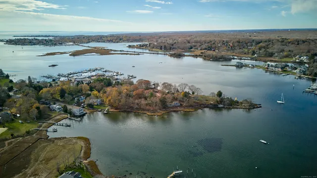an aerial view of ocean and residential houses with outdoor space