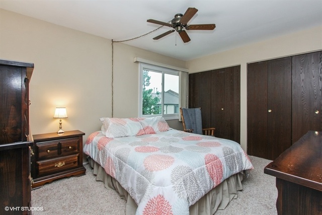 108 Ginger Court Rolling Meadows, IL 60008 - Photo 10 of 15 a bedroom with a bed and a chandelier