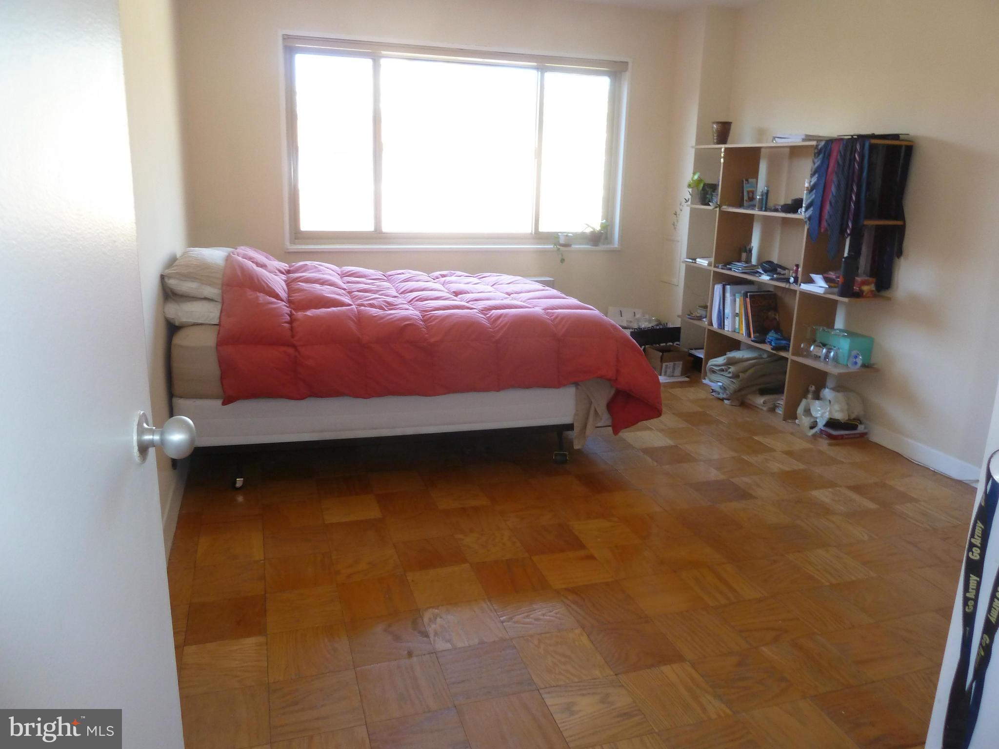 3900 Tunlaw Road Northwest, Unit 610 Washington, DC 20007 - Photo 14 of 22 a bedroom with a bed and furniture