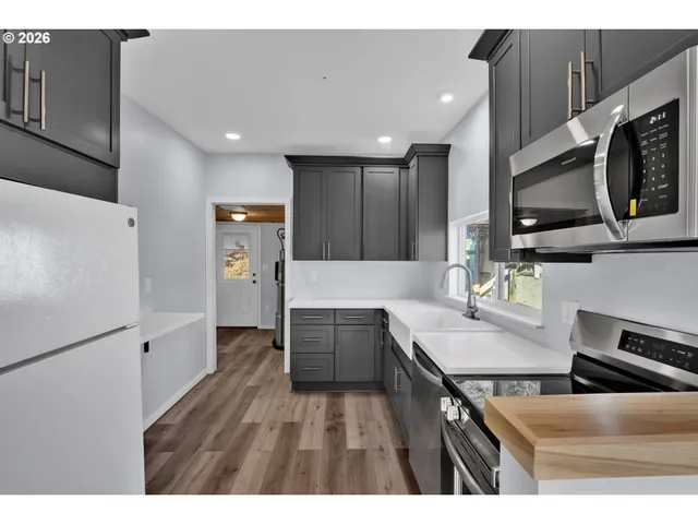 a kitchen with a sink dishwasher a stove and a microwave oven