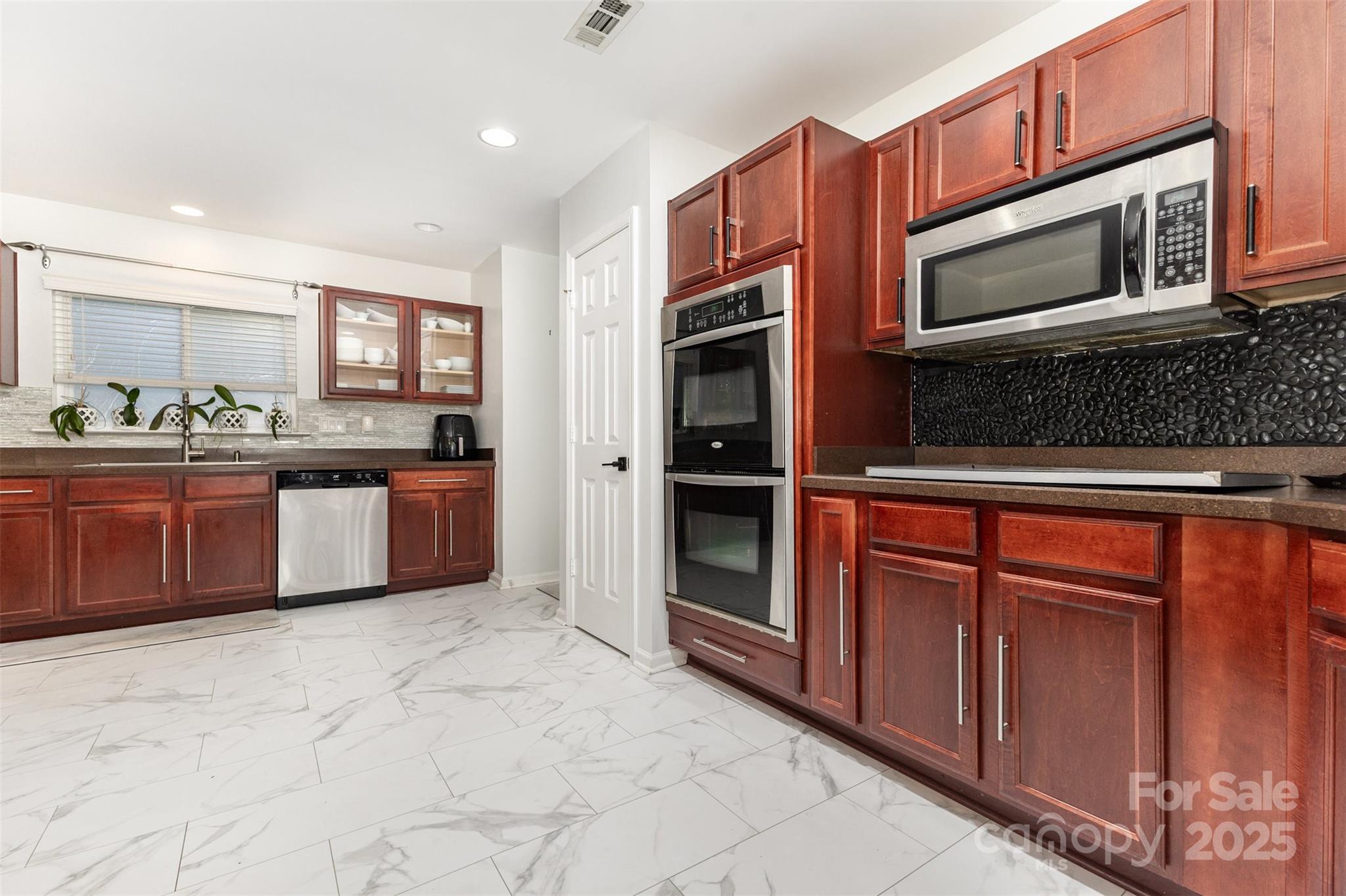 6706 Evanton Loch Road Charlotte, NC 28278 - Photo 13 of 32 a kitchen with stainless steel appliances granite countertop a stove microwave and sink