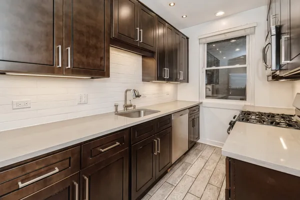 a kitchen with a sink stove and cabinets