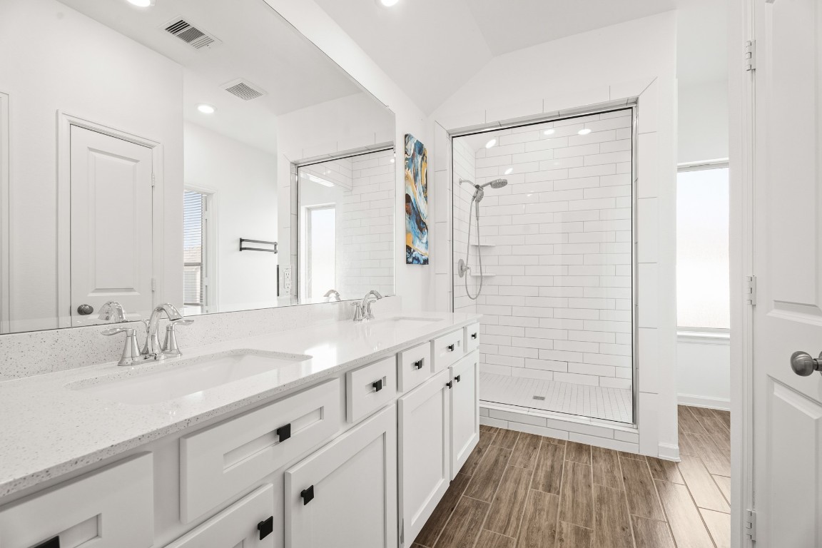 4103 Balboa Drive Iowa Colony, TX 77583 - Photo 16 of 30 a bathroom with a double vanity sink a mirror and a shower