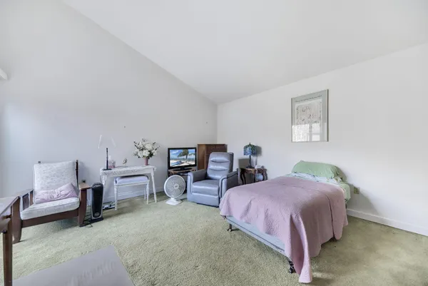 a bedroom with bed and a lounge chair