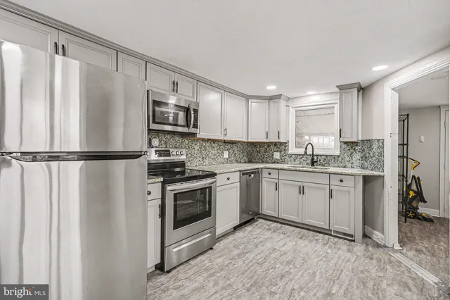 a kitchen with granite countertop stainless steel appliances a refrigerator sink and microwave