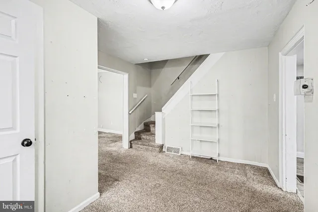 an empty room with a staircase and white walls