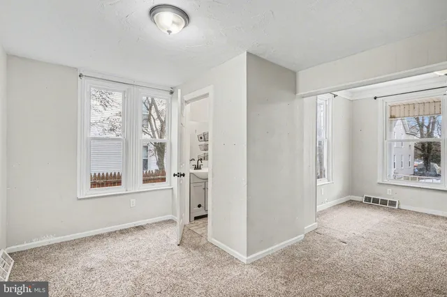 an empty room with windows and closet