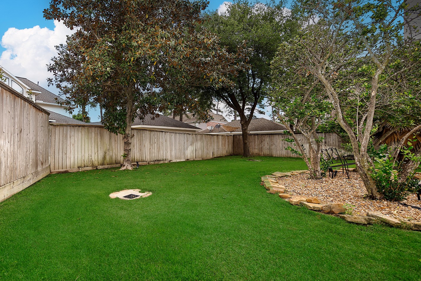18834 Forest Elms Drive Spring, TX 77388 - Photo 37 of 47 a view of a backyard with table and chairs and wooden fence