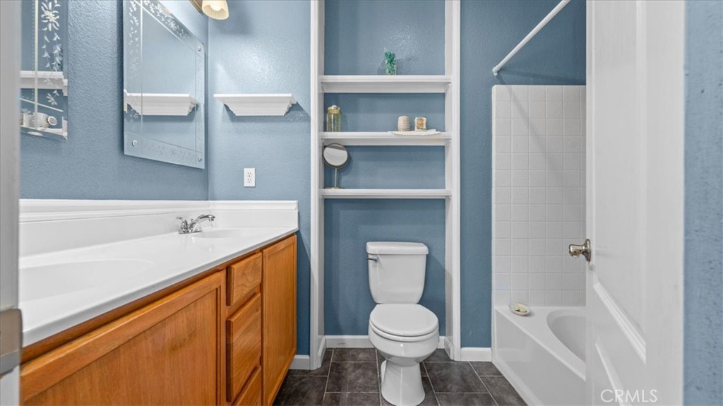 11450 Church Street, Unit 4 Rancho Cucamonga, CA 91730 - Photo 19 of 38 a bathroom with a bathtub sink vanity mirror and toilet