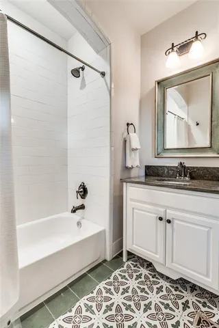 a bathroom with a tub sink and mirror