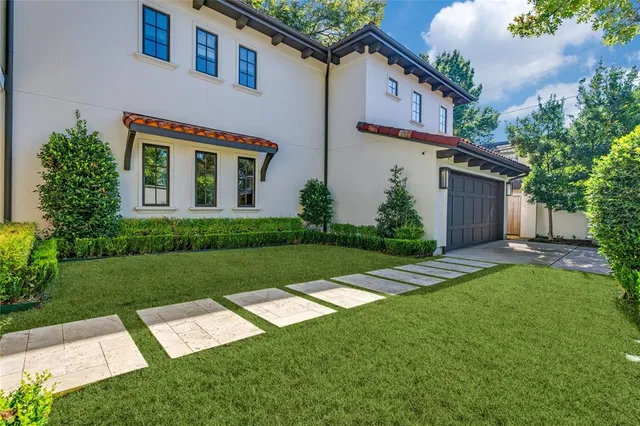 a front view of a house with a yard and trees