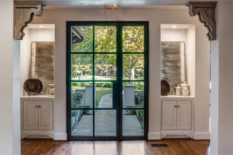 a view of hallway with a large window and wooden floor