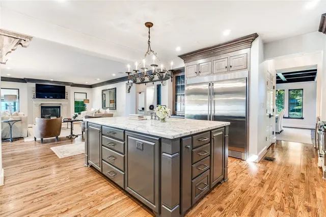 a kitchen with stainless steel appliances granite countertop a sink and a wooden floor