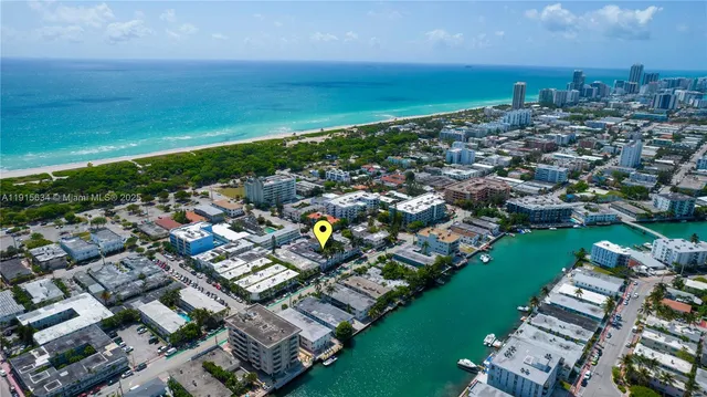 an aerial view of a city with lots of residential buildings ocean and mountain view in back