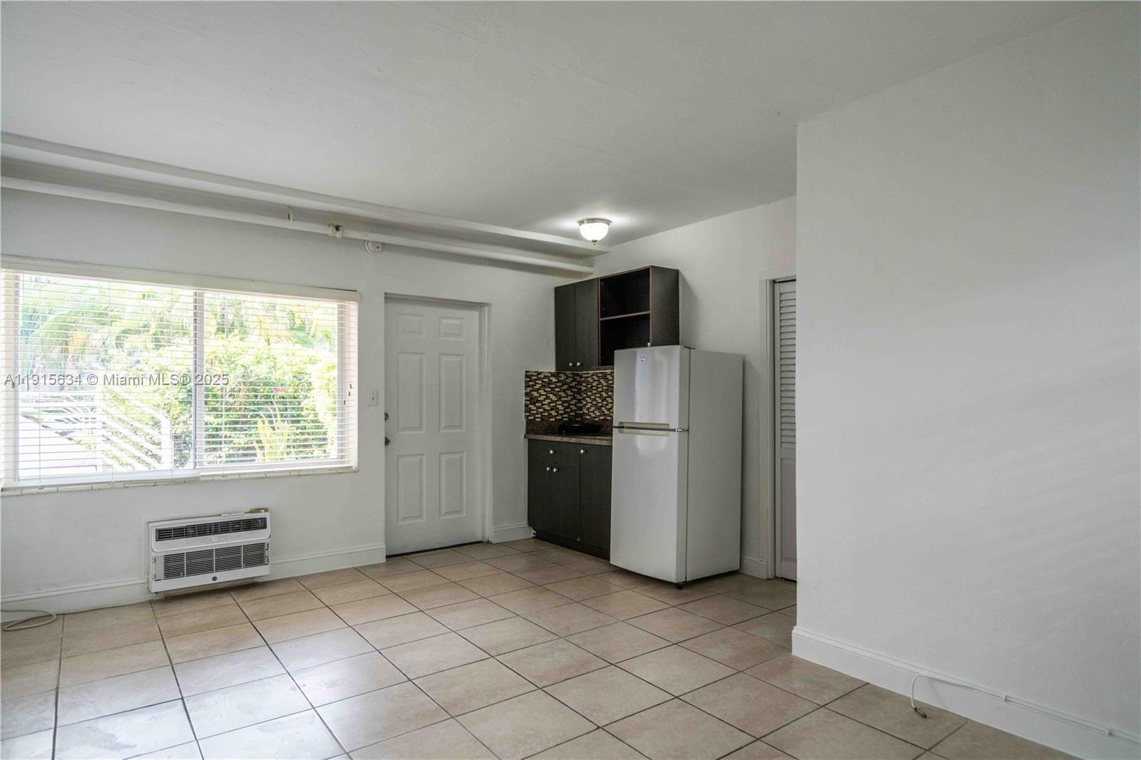 8315 Byron Avenue, Unit 2A Miami Beach, FL 33141 - Photo 3 of 13 a kitchen with a refrigerator and a stove top oven