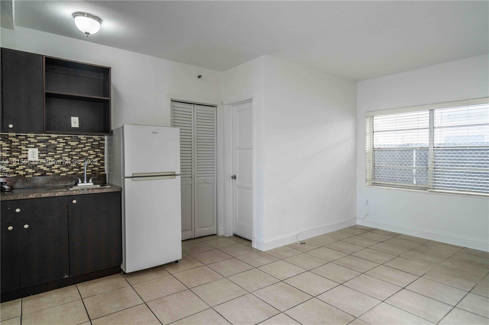 8315 Byron Avenue, Unit 2A Miami Beach, FL 33141 - Photo 4 of 13 a view of kitchen with a sink refrigerator and window