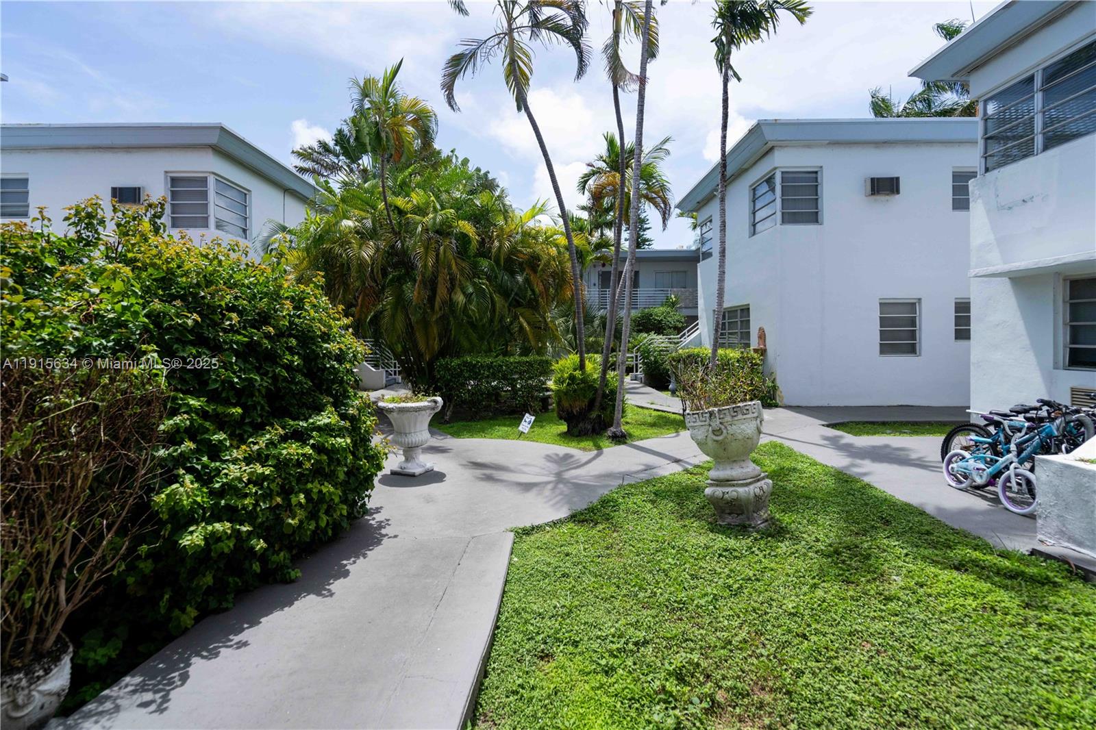 8315 Byron Avenue, Unit 2A Miami Beach, FL 33141 - Photo 8 of 13 a front view of a house with a yard and a garden