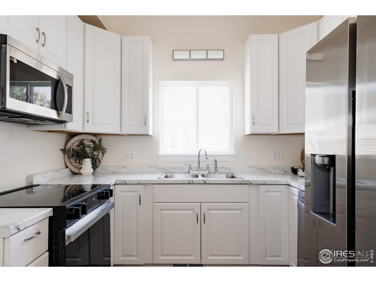 934 6th Street Berthoud, CO 80513 - Photo 8 of 28 a kitchen with stainless steel appliances granite countertop a sink stove and microwave