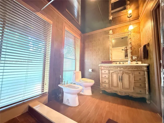 a bathroom with a granite countertop sink mirror vanity and a toilet