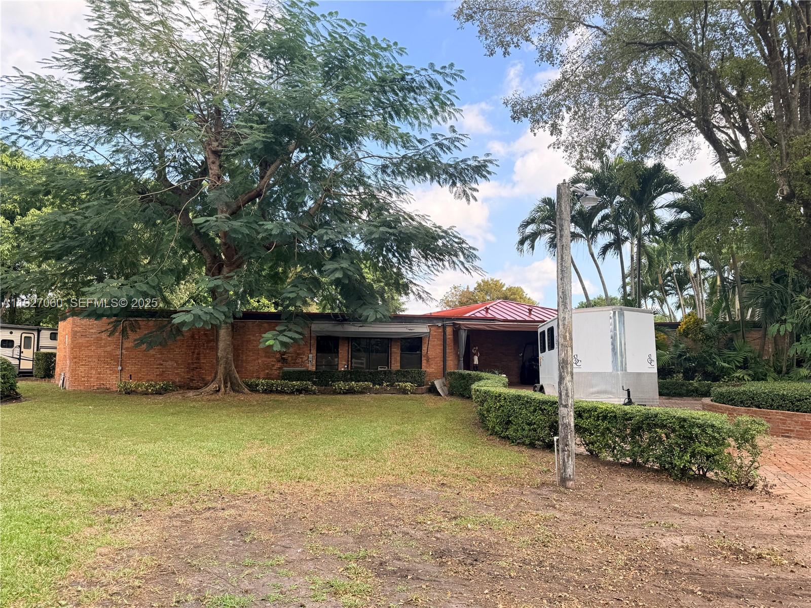 5877 Southwest 123rd Avenue, Unit MAIN Miami, FL 33183 - Photo 30 of 34 a view of a house with a yard and large trees