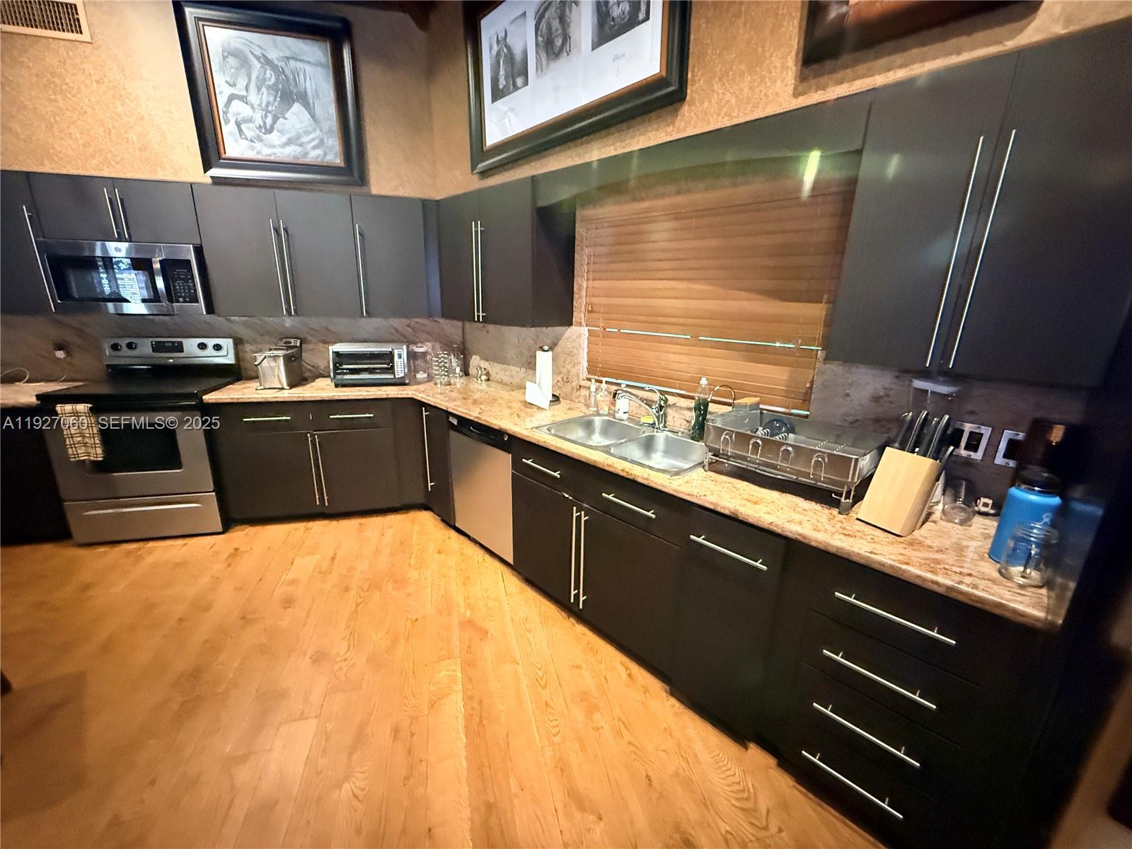 5877 Southwest 123rd Avenue, Unit MAIN Miami, FL 33183 - Photo 8 of 34 a kitchen with stainless steel appliances wooden cabinets a sink and a stove