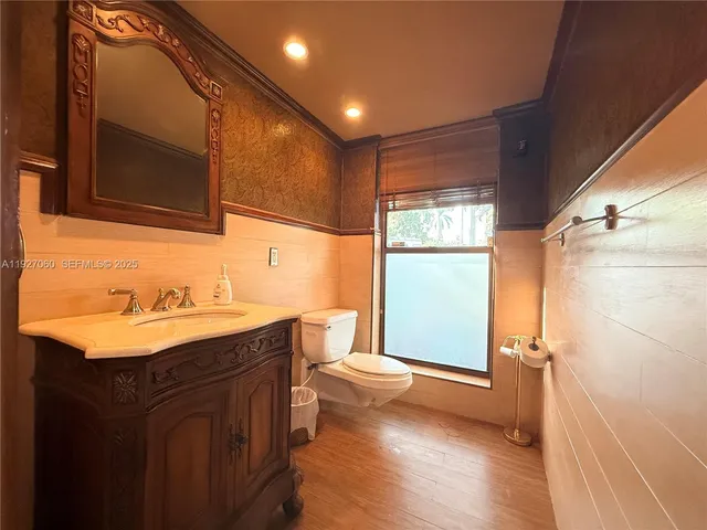 a bathroom with a sink toilet double vanity and mirror