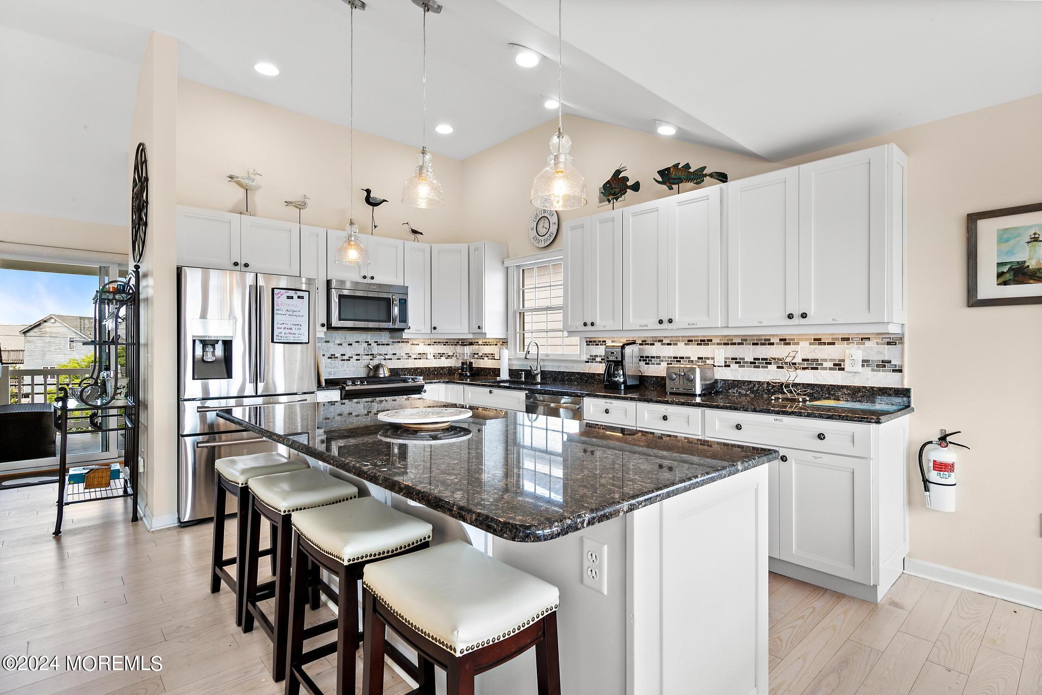 10 Arnold Boulevard Beach Haven, NJ 08008 - Photo 11 of 81 a kitchen with stainless steel appliances granite countertop a stove top oven a refrigerator a sink and a dining table with wooden floor