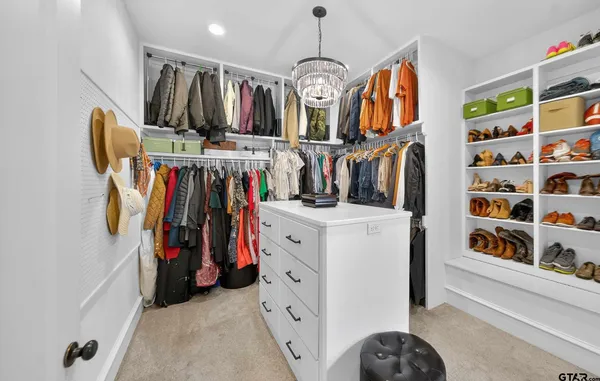 a view of walk in closet with clothes and shoes