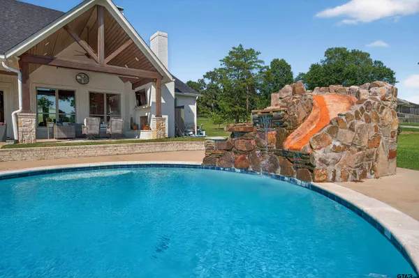 a view of a swimming pool with a bench and some trees