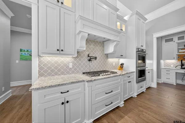 a kitchen with stainless steel appliances granite countertop a stove and cabinets