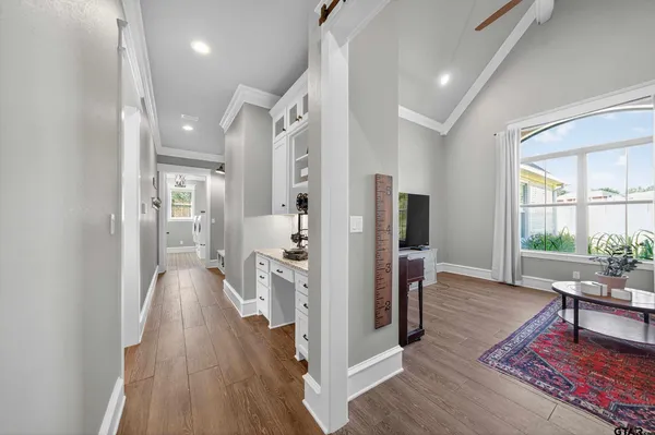 a view of a hallway with wooden floor and a livingroom