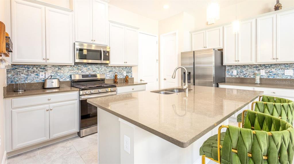 2278 Datura Loop St. Cloud, FL 34772 - Photo 11 of 31 a kitchen with a sink a stove and cabinets