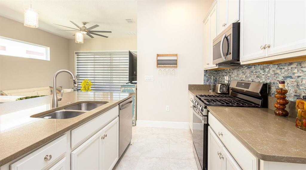 2278 Datura Loop St. Cloud, FL 34772 - Photo 12 of 31 a kitchen with stainless steel appliances granite countertop a sink stove and cabinets