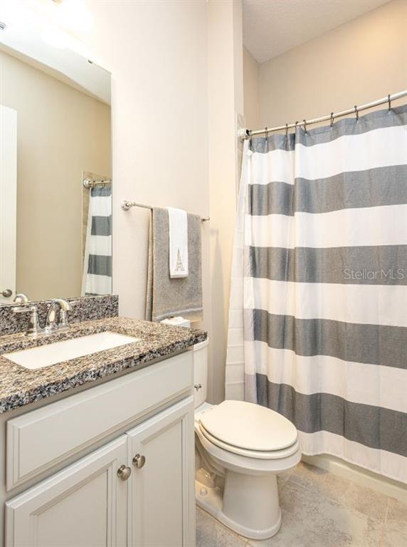 2278 Datura Loop St. Cloud, FL 34772 - Photo 24 of 31 a bathroom with a granite countertop toilet a sink and a mirror