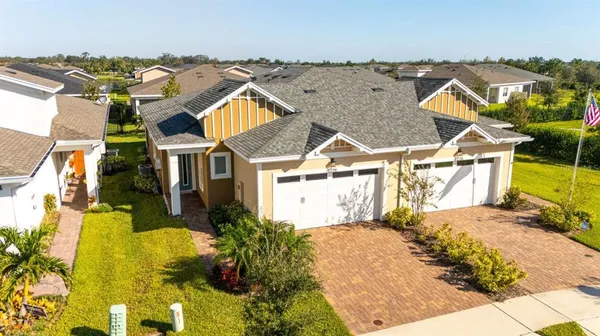 an aerial view of residential houses with outdoor space and parking
