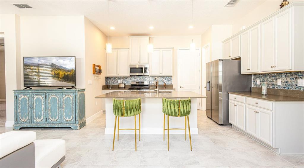 2278 Datura Loop St. Cloud, FL 34772 - Photo 10 of 31 a kitchen with stainless steel appliances granite countertop a stove a sink and a refrigerator