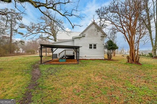 a view of a house with backyard and tree