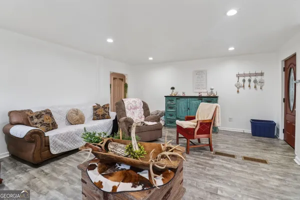a living room with furniture and a wooden floor