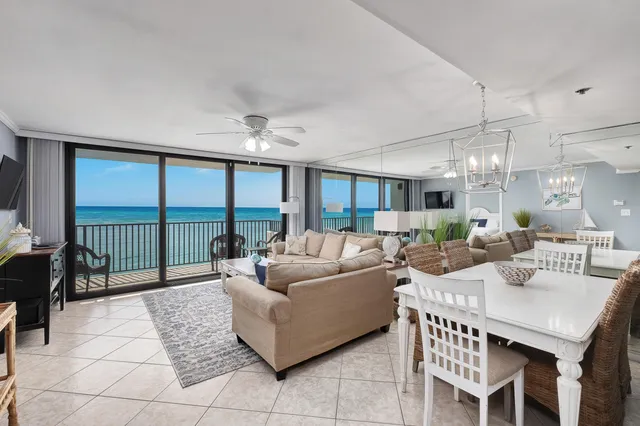 a living room with furniture a floor to ceiling window and flat screen tv