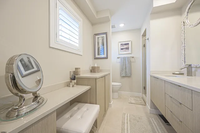 a bathroom with a granite countertop sink a toilet and a mirror