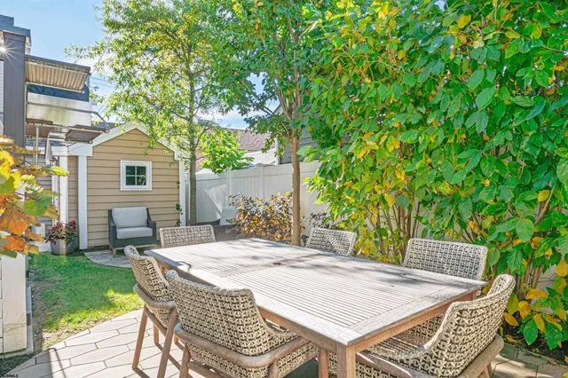 a patio with a table and chairs and potted plants