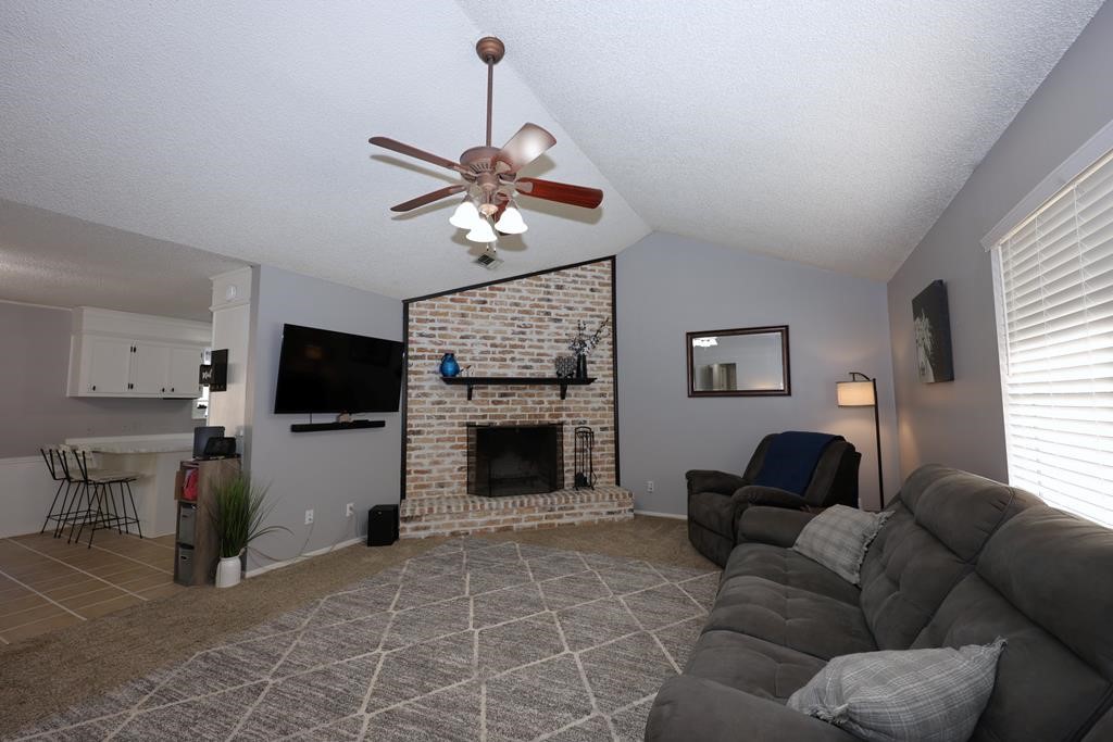 235 Spring Branch Street Lufkin, TX 75904 - Photo 2 of 30 a living room with furniture a flat screen tv and a fireplace