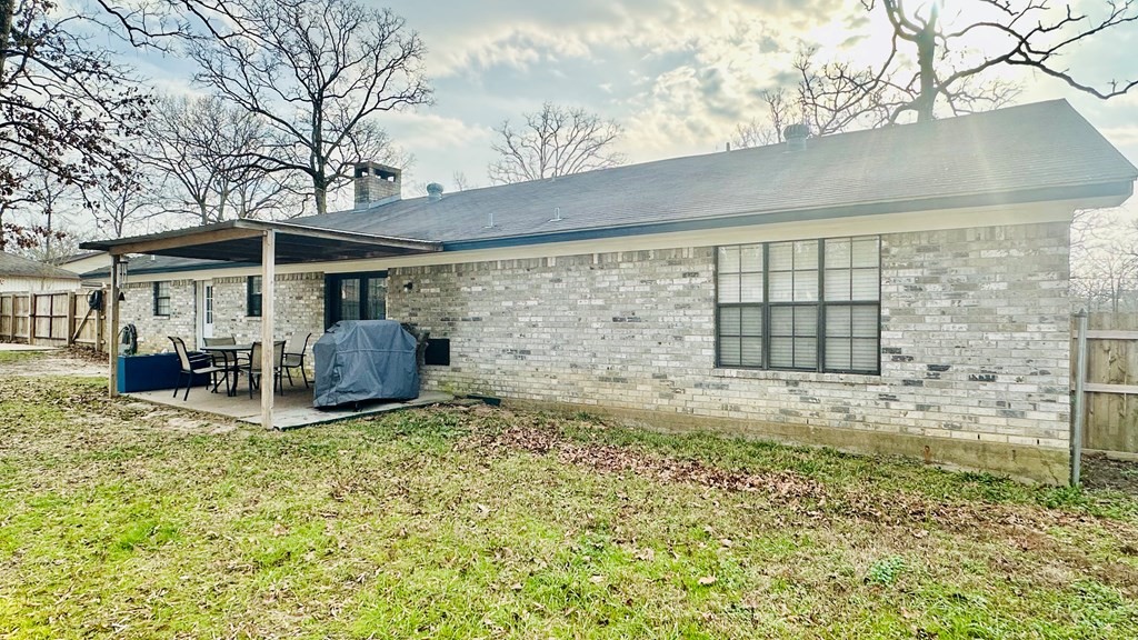 235 Spring Branch Street Lufkin, TX 75904 - Photo 25 of 30 a view of a patio with table and chairs under an umbrella
